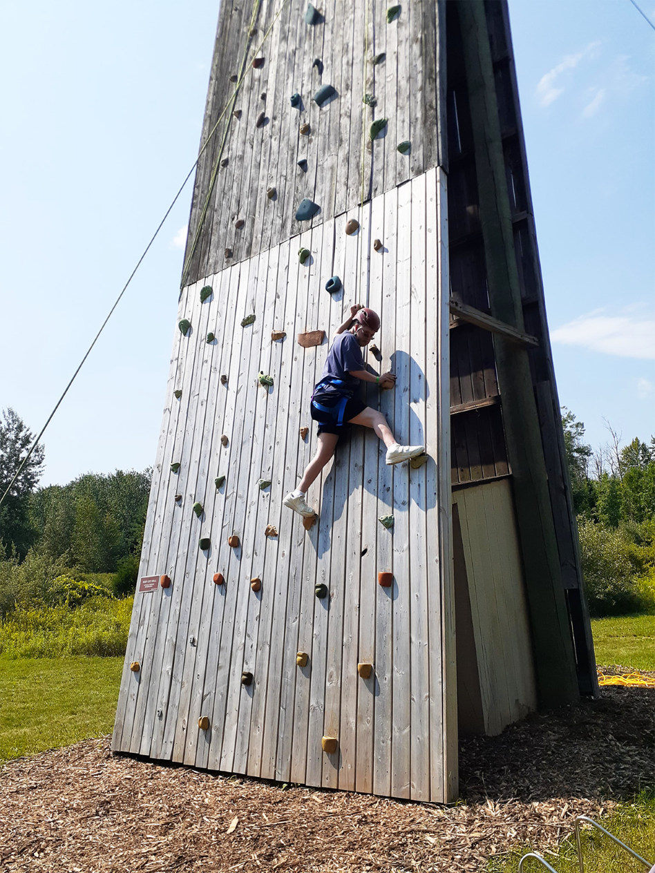 A camper climbs the rock wall at The Fowler Center, a camp that empowers special needs people to reach their limits