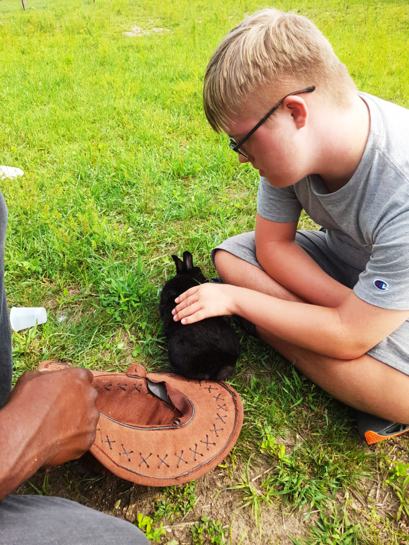 A camper pets one of the rabbits at The Fowler Center 