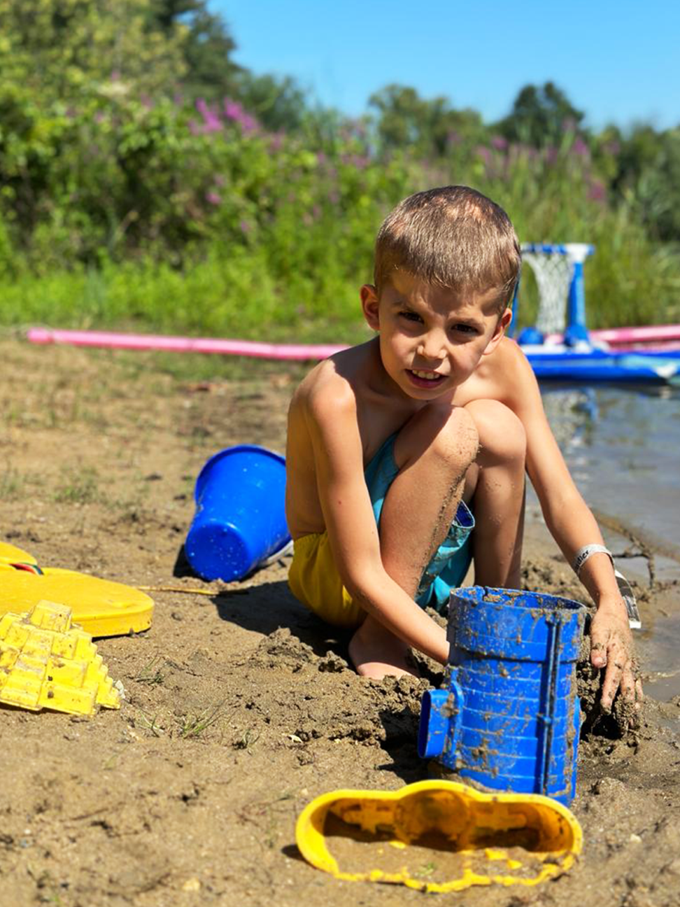 A little boy digs in the sand at the lake. The Fowler Center has plenty of activities that encourage exploration and fun!